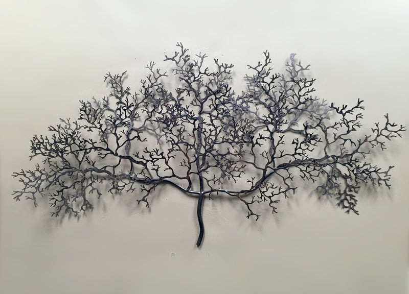  Hand-made tree branch-like wall art made from crushed metal, displayed against a concrete rendered wall.